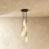 A small cluster of lit alabaster cylinders hung at three different heights