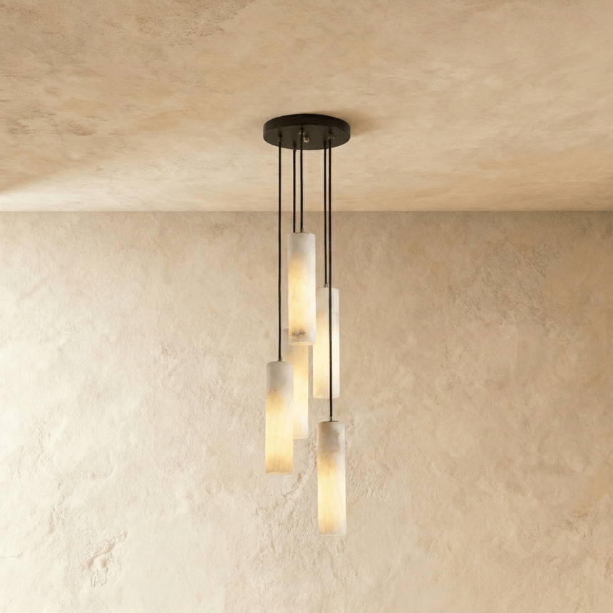 A small cluster of lit alabaster cylinders hung at three different heights