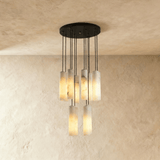 A tall cluster of lit stone cylinders dropping in steps from a black plate