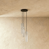 Three unlit alabaster cylinders on black cords from a small round plate