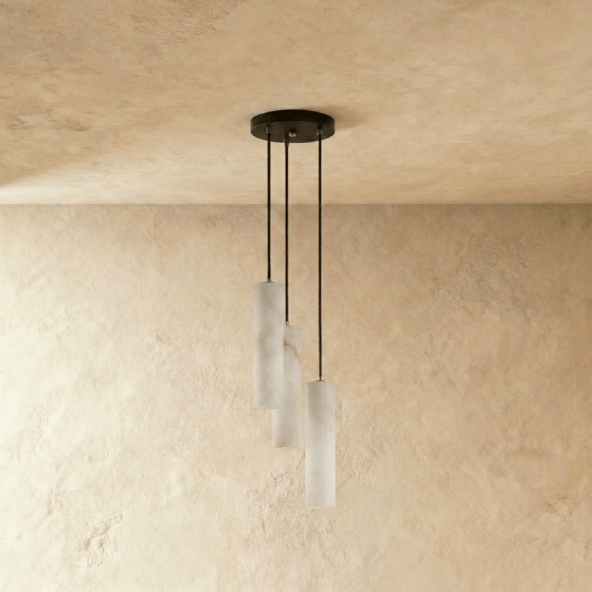 Three unlit alabaster cylinders on black cords from a small round plate