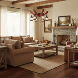 Chandelier lit in a living room above a sofa and a wide rug