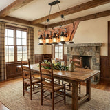 Chandelier lit above a wood dining table in a room with a fireplace