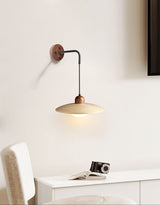 Sconce lit above a white console holding a camera beside a pale chair