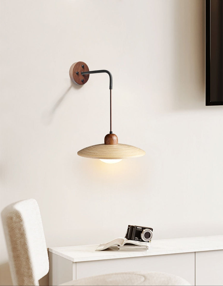 Sconce lit above a white console holding a camera beside a pale chair