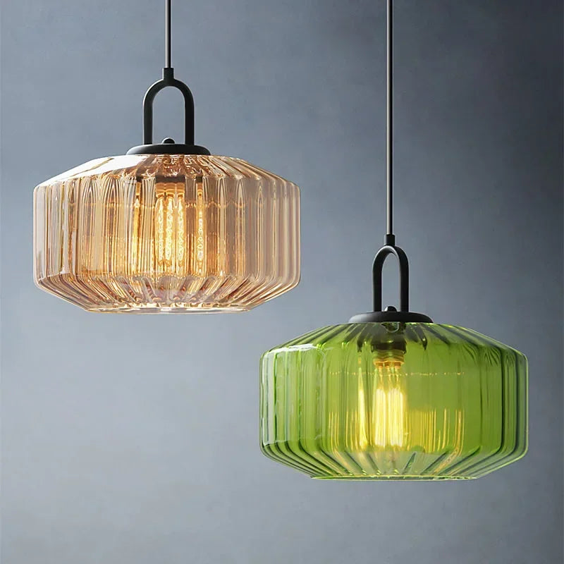 Amber and green ribbed drums hanging at two heights on a blue gray wall