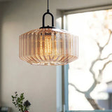 Amber ribbed drum lit against a bright window with bare branches outside