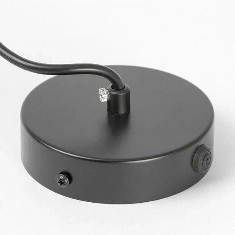 Close view of the black ceiling plate with the cord outlet and fixing screw