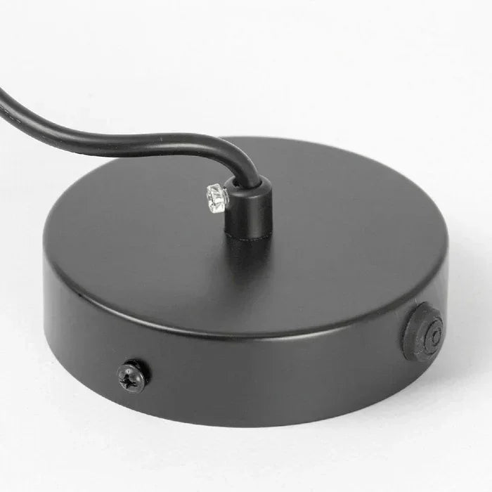 Close view of the black ceiling plate with the cord outlet and fixing screw