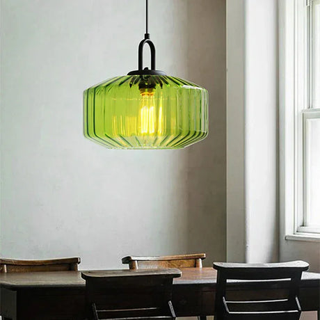 Green ribbed drum above a cafe table with dark chairs and a pale wall