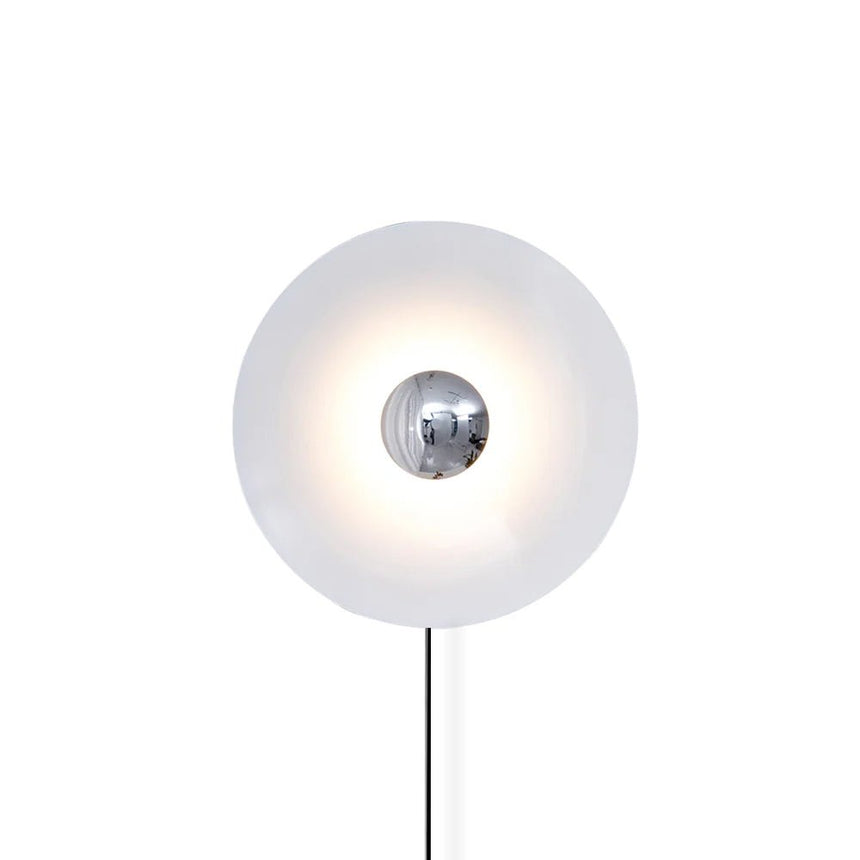 The white disc with a chrome center and its cord on a white background