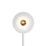 The white disc with a copper tone center and its cord on a white background