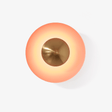 Round orange disc wall light with a copper tone center that glows around its edge
