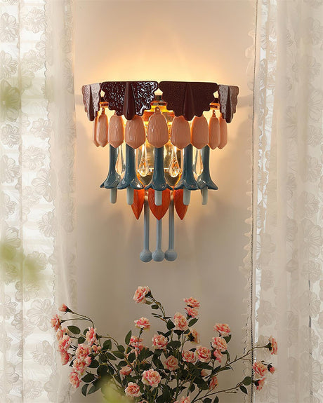 The sconce lit between sheer curtains above a bunch of pink roses