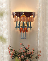 The sconce glowing warm between sheer curtains, pink roses below