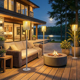 Two lit on decking beside a sofa and a lit fire bowl at night