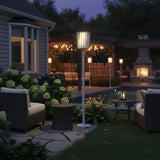 The lamp lit on a lawn beside hydrangeas with a lit house behind