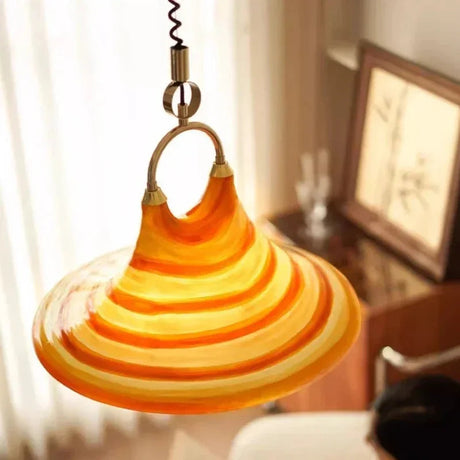 The striped cone lit beside a framed artwork on a pale wall