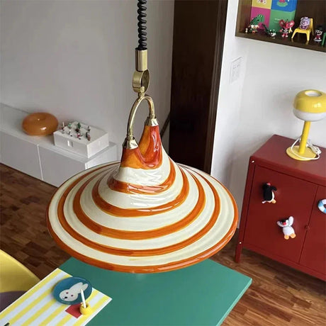 The striped cone lit above a desk corner with books and a red box