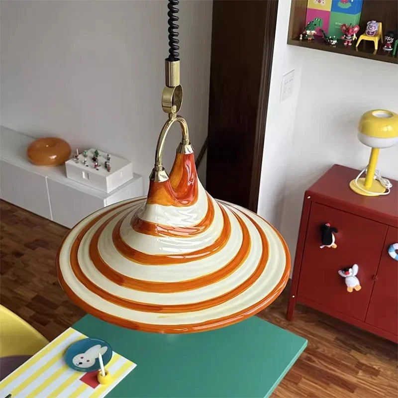 The striped cone lit above a desk corner with books and a red box