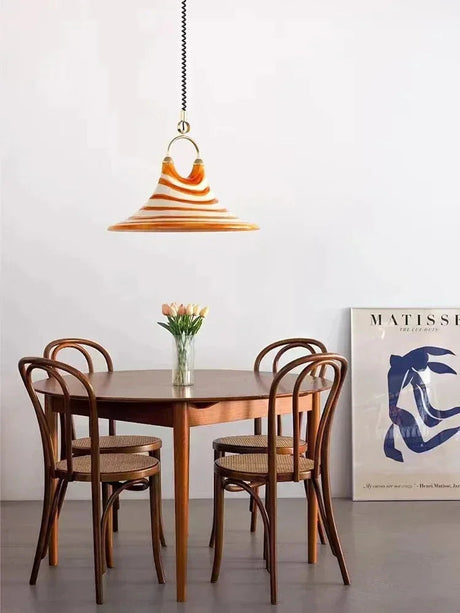 The striped cone lit above a round table with bentwood chairs