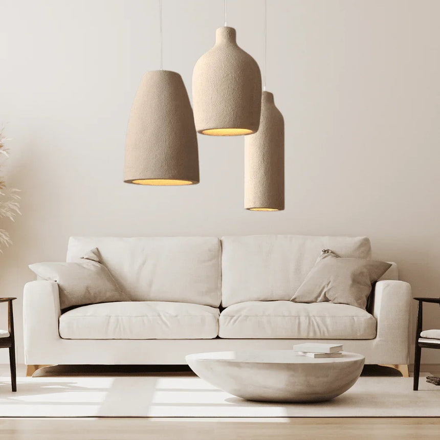 Three tapered resin shades hung above a cream sofa