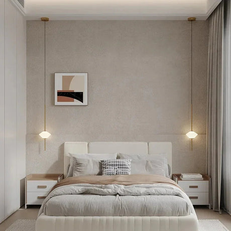 Two cone shades hung either side of a bed with a wide upholstered headboard