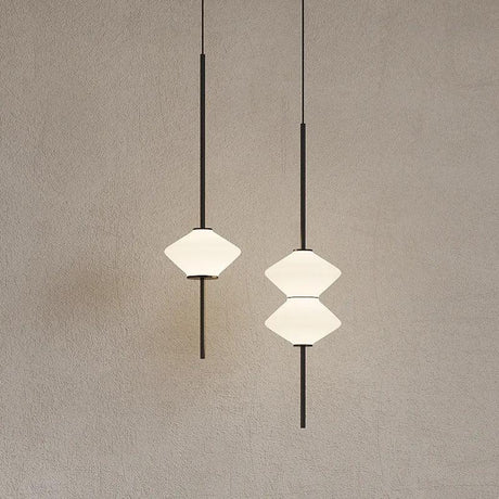 Two white double cone shades on brass rods against a warm plaster wall