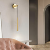 The brass cone beside an arched doorway above a pink tufted sofa