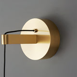 Close view of the round brass wall plate and the cable holder