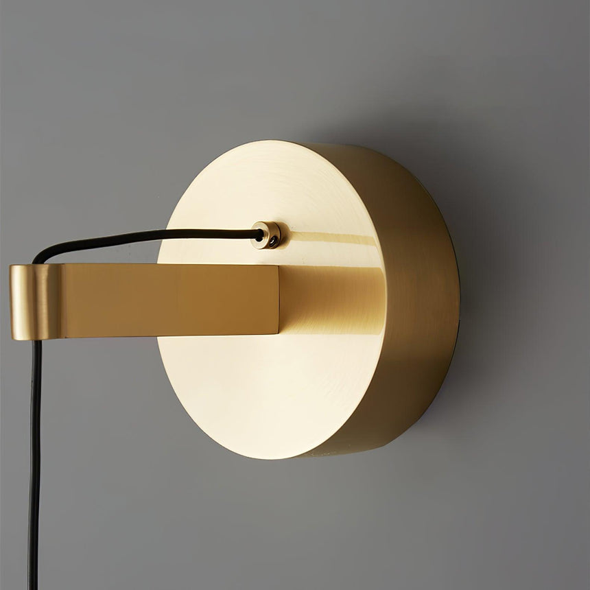 Close view of the round brass wall plate and the cable holder
