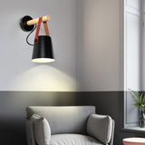 Sconce lit above a sofa beside a window with a side table below it