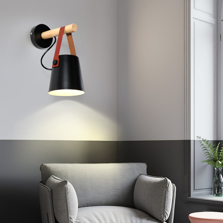 Sconce lit above a sofa beside a window with a side table below it