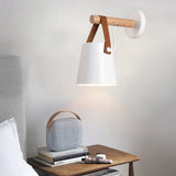 White cone lit above a table with books, a speaker and a curtain beside
