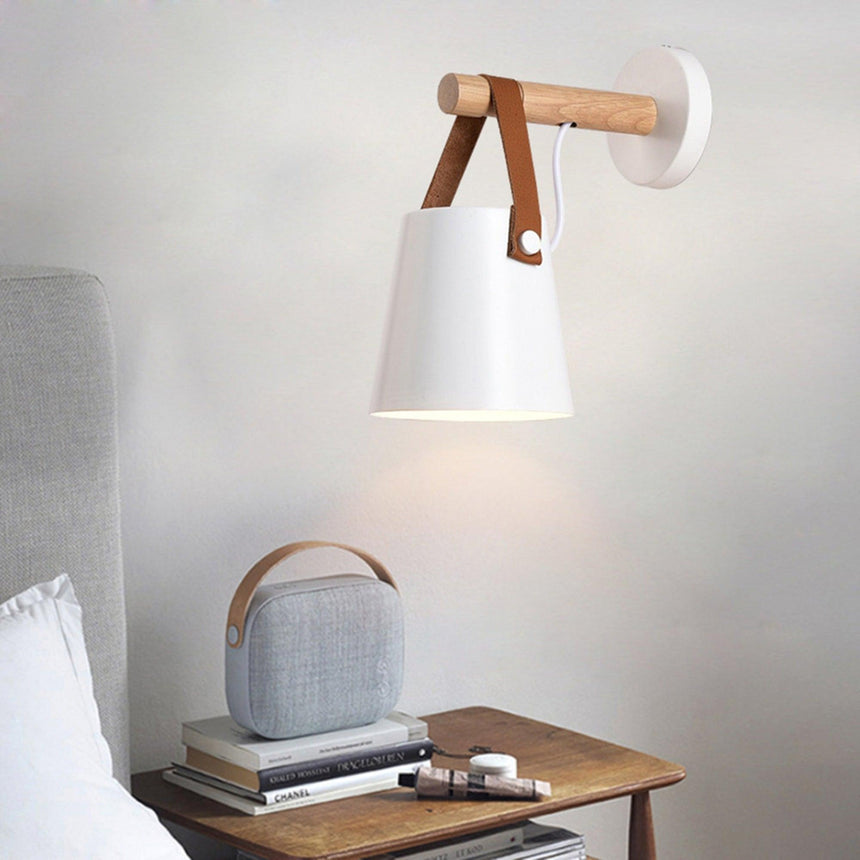 White cone lit above a table with books, a speaker and a curtain beside