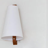 The leather tab that fastens the parchment shade to the wood bracket