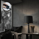 Console table lamp in black on a table beside a draped chair