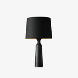Console table lamp in black seen from the front on a pale ground