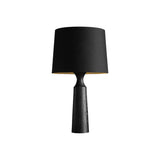 Console table lamp in black seen from the side on a pale ground