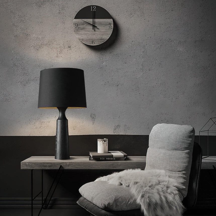 Console table lamp in black on a console below a round wall clock