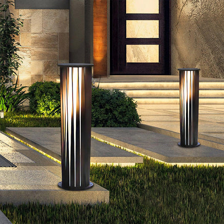 Two lit either side of a lit entry with grass and clipped shrubs