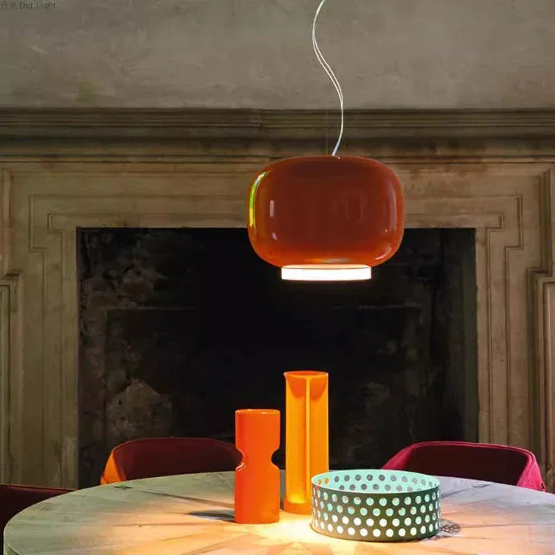 Orange glass pendant light above a round dining table