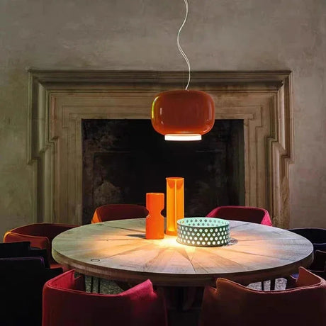 Orange glass shade above a table in a room with a fireplace