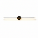 The black rod lit, the diffuser bright along its underside on a pale wall