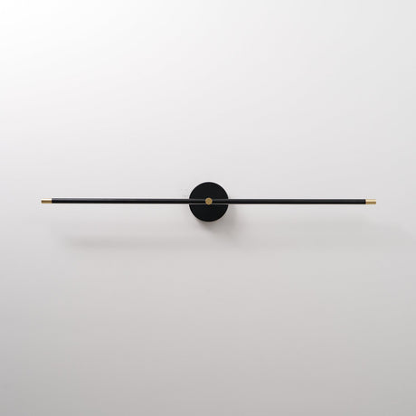 The black rod seen unlit, a thin bar through a round hub on a pale wall