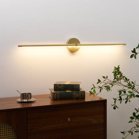 Gold rod lit above a walnut cabinet with books and trailing foliage beside it