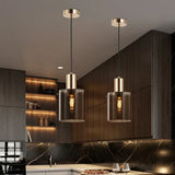 Two copper pendants lit above a wooden kitchen counter and shelves