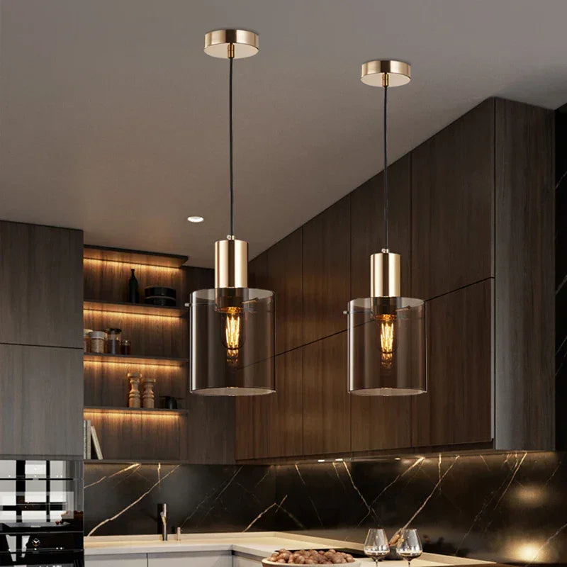 Two copper pendants lit above a wooden kitchen counter and shelves