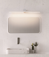 Black bar lit above a rounded mirror over a stone basin and a small plant