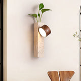 Wall sconce lit above a dining chair, the head turned toward the table